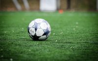 white and blue soccer ball on green grass field during daytime